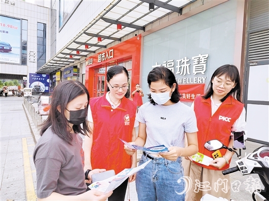 恩平人保財險工作人員向群眾派發(fā)宣傳折頁，普及金融知識。