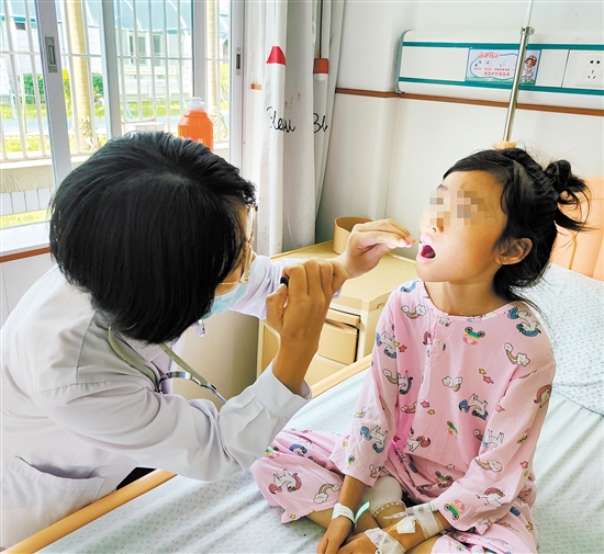 兒科醫(yī)生為手足口病患兒檢查身體情況。