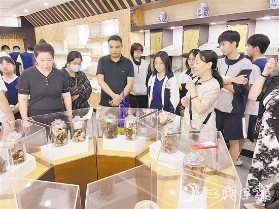 講解員向參觀者們講解標本瓶里的珍貴藥材。