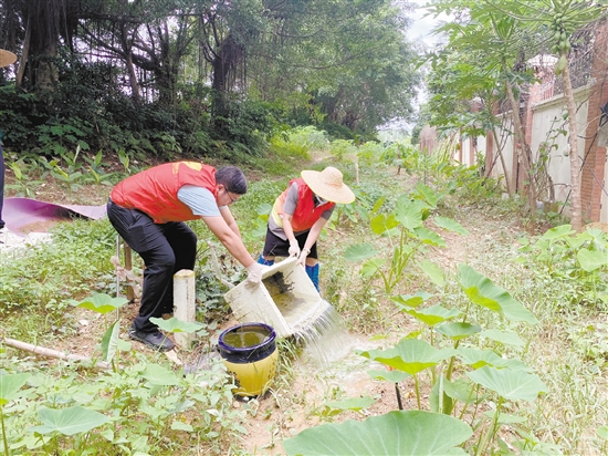 工作人員清理環(huán)境積水。