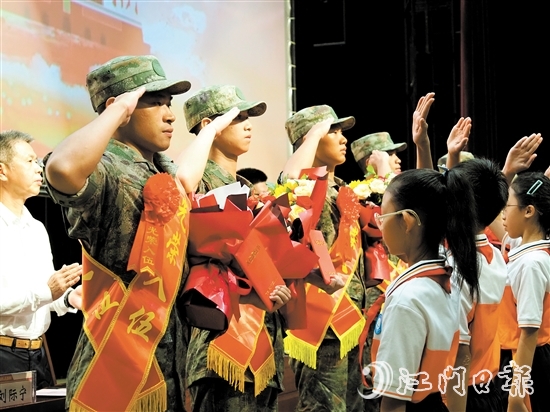 小學(xué)生代表向入伍新兵代表獻(xiàn)上鮮花。