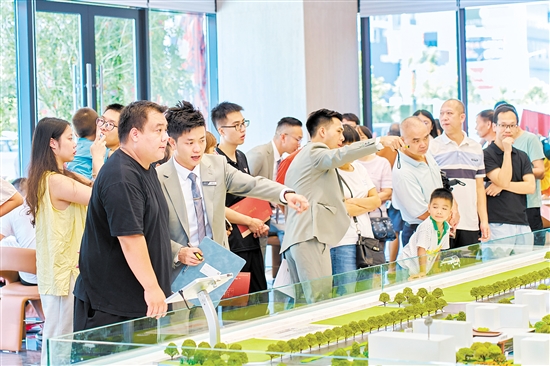 在駿景灣·品悅，銷售人員忙著為客戶介紹樓盤情況。
