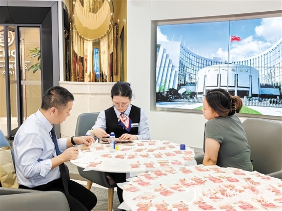 工行江門分行營業(yè)部工作人員為客戶鑒別殘幣。