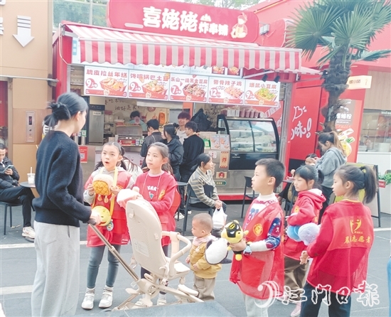 統(tǒng)一身著志愿者服裝的孩子們化身“愛心小掌柜”，向顧客推銷商品。