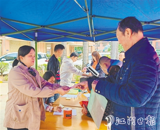 業(yè)委會工作人員向業(yè)主派發(fā)現(xiàn)金福利。