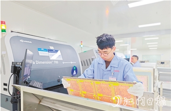 在鶴山中富生產(chǎn)車間，員工操作自動(dòng)化設(shè)備趕制電路板。