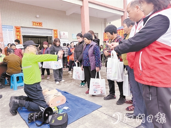 在應(yīng)急安全知識(shí)宣講攤位前，志愿者耐心講解示范急救技能，提升村民的安全意識(shí)和自救互救能力。
