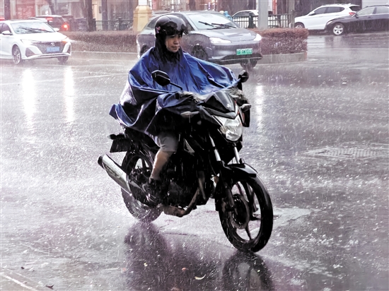 昨天，在市區(qū)東華一路，一位市民騎著摩托車在雨中前行。