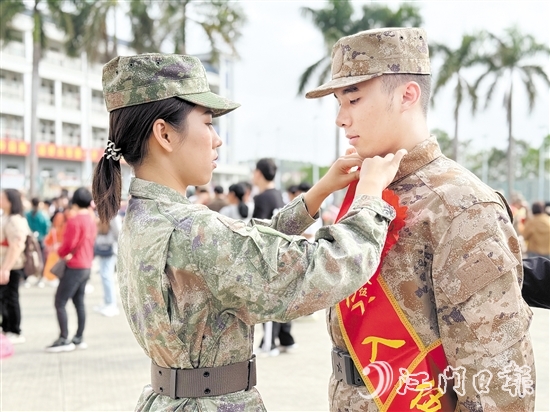 在歡送儀式現(xiàn)場，老兵姐姐為新兵弟弟整理軍裝。