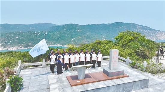 江門市青年學生國家安全志愿者宣傳隊成員在江門圍夾島領?；c為領海界碑描紅。
