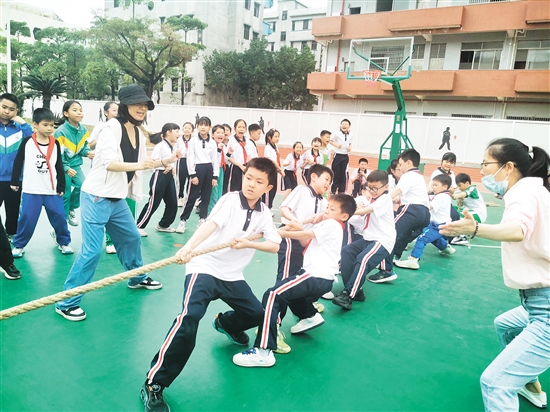 雙方隊(duì)員緊握長繩，齊心協(xié)力，鼓足勁拼命往后拉，全力以赴為班級榮譽(yù)而戰(zhàn)。