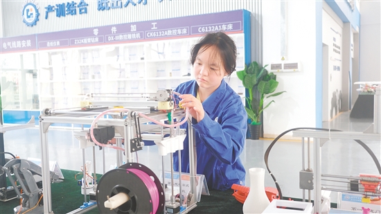 馮曉熒在操作3D打印機(jī)。