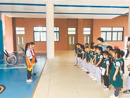紅領(lǐng)巾講解員帶領(lǐng)孩子參觀校園。