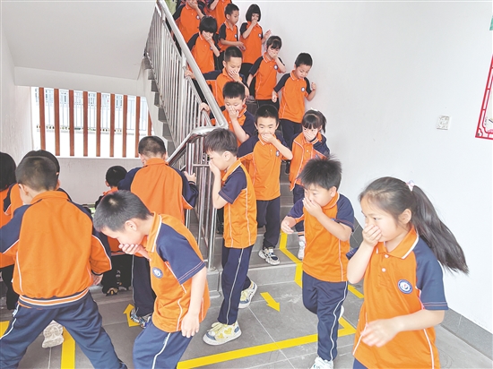 學(xué)生們彎腰低頭、捂住口鼻，按照預(yù)定路線有序撤離。
