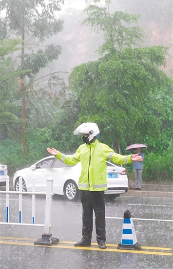 高考期間，交警在大雨中維持交通秩序。