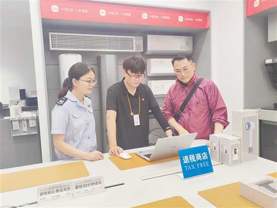 稅務(wù)部門輔導(dǎo)小米之家工作人員為旅客開具退稅申請單。