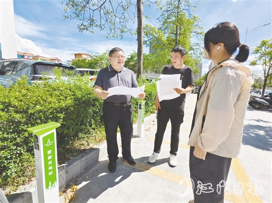 余中宏（左一）與同事一起查看“民生服務(wù)充電站”項(xiàng)目建設(shè)進(jìn)度。
