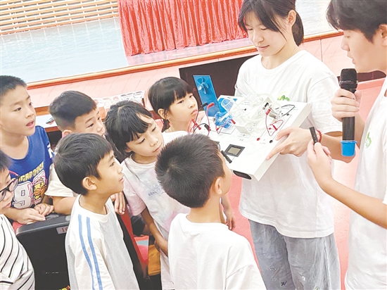 服務(wù)隊(duì)隊(duì)員向孩子們展示氫燃料電池演示儀。