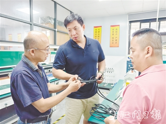 盧慶忠（中）與技術(shù)人員交流產(chǎn)品質(zhì)量問(wèn)題。