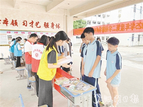 工作人員向?qū)W生宣傳防溺水知識。