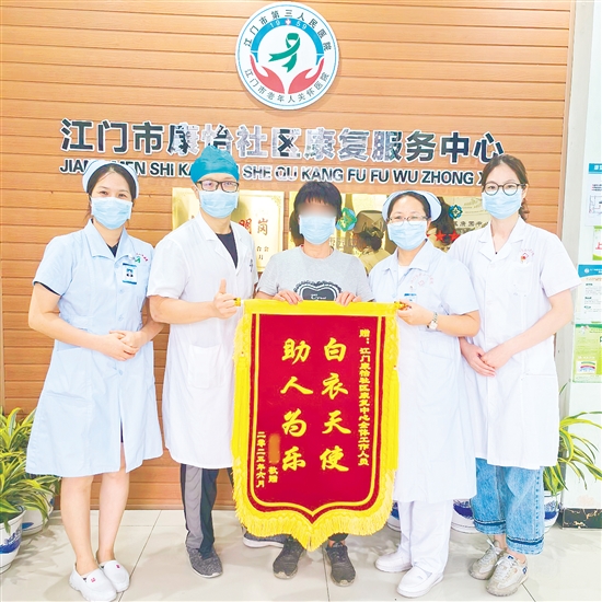 李明給康復中心醫(yī)護人員送上錦旗。