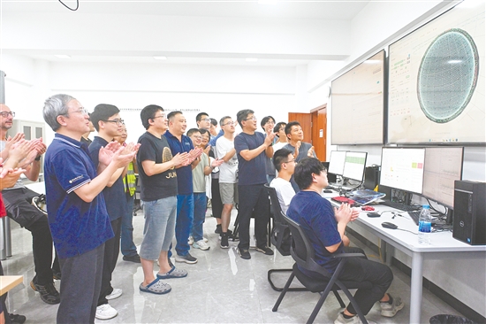 8月26日，科研人員在江門中微子實驗運行控制室共同開啟物理取數(shù)，鼓掌慶祝取數(shù)成功。