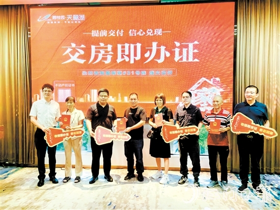 業(yè)主喜拿房產(chǎn)證和鑰匙。